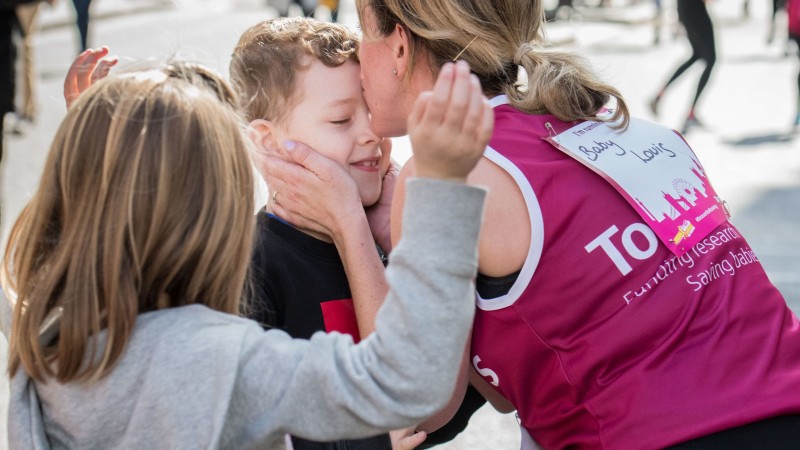 A Tommy's runner stopping to kiss her son